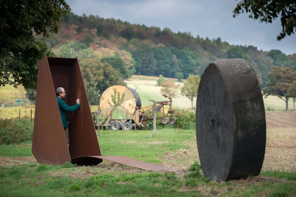 Michael Zwingmann beim Reinigen seiner Skulptur im ländlichen Raum.